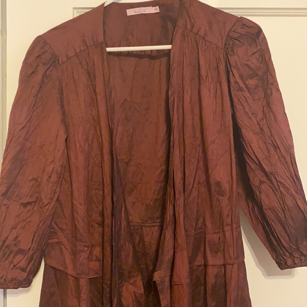 Dark maroon cover up, raincoat styling, two ties in the front and puffy sleeves